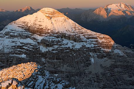 Dawn from the top of Tofana di Mezzo (3244 m) towards Tofana di Rozes after a slight summer snowfall, in the background the Marmolada glacier, Cortina d'Ampezzo, dolomites, Italy
