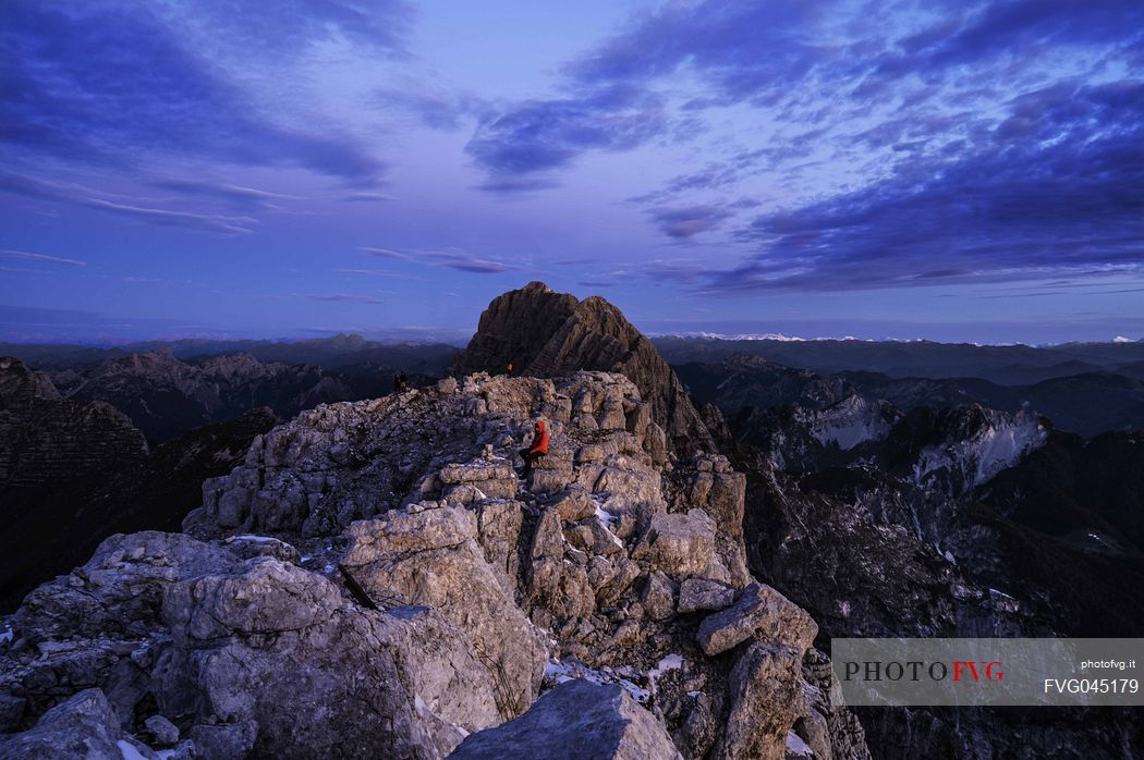 Hikers at the first light of the day from the top of the Foronon del Buinz near the Luca Vuerich hut, Montasio mount, Julian alps, Friuli Venezia Giulia, Italy, Europe