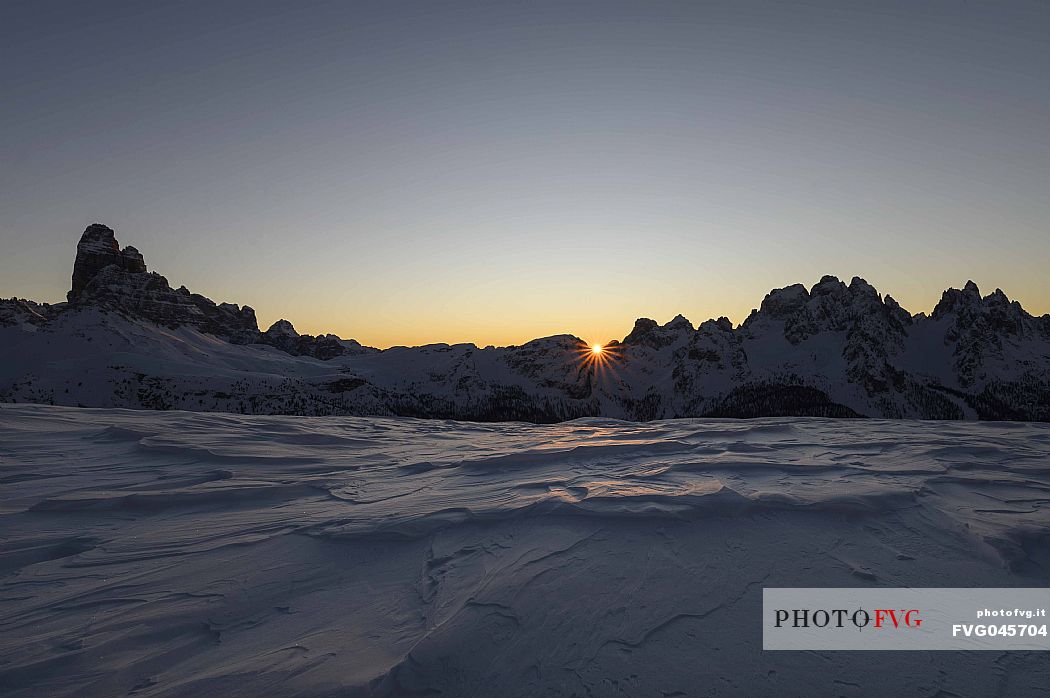 The sun rises behind Le Ciampedele, between the western side of the Tre Cime di Lavaredo and the Cadini di Misurina, on a frosty december morning, dolomites, South Tyrol, Italy, Europe