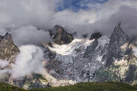 Les Grandes Jorasses partially hidden by clouds, from the grassy hill at the entrance to the Vallon de Malatr, val ferret, Courmayeur, Aosta valley, Italy, Europe