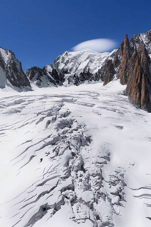 Top of Mont Blanc wrapped in lenticular cloud, crevasse on the Glacier du Gant, Courmayeur, Aosta valley, Italy, Europe