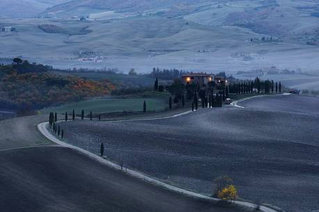 Dirt road and farm in the Val d'Orcia or Orcia valley at twilight, Tuscany, Italy, Europe