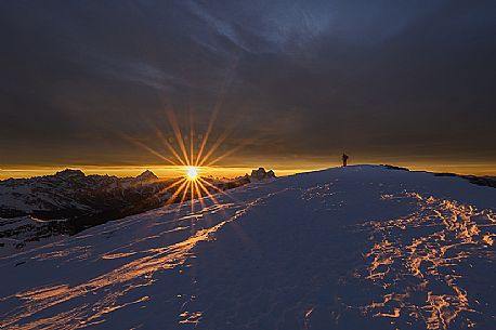 Hiker on the top of Lagazuoi mountain at dawn, in the background Sorapiss, Antelao and  Pelmo, dolomites, Cortina d'Ampezzo, Veneto, Italy, Europe
