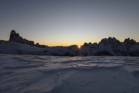 The sun rises behind Le Ciampedele, between the western side of the Tre Cime di Lavaredo and the Cadini di Misurina, on a frosty december morning, dolomites, South Tyrol, Italy, Europe The sun rises behind Le Ciampedele, between the western side of the Tre Cime di Lavaredo and the Cadini di Misurina, on a frosty december morning, dolomites, South Tyrol, Italy, Europe