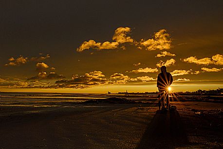 Man admires the sunset in Caorle after a thunderstorm, Adriatic sea, Veneto, Italy, Europe