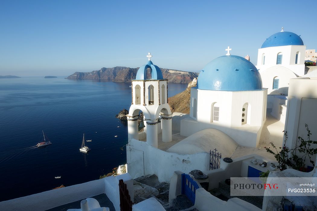 Church roof in Oia village and Caldera in the background, Santorini island, Greece