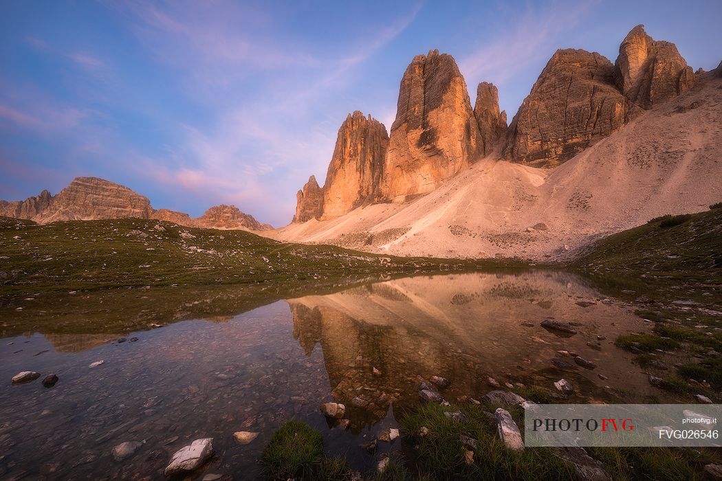 Tre Cime di Lavaredo, Drei Zinnen, reflected in a small lake at sunset, dolomites, Italy