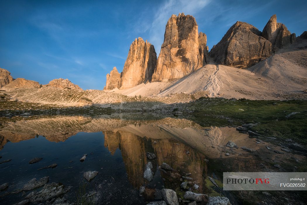 Tre Cime di Lavaredo, Drei Zinnen, reflected in a small lake at sunset, dolomites, Italy