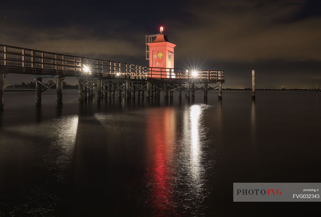 Night view of lighthouse and pier in Punta Faro, Lignano Sabbiadoro, Friuli Venezia Giulia, Italy