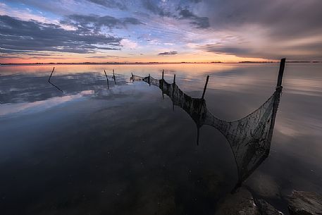 Fish nets in the Grado lagoon at sunset, Friuli Venezia Giulia, Italy Fish nets in the Grado lagoon at sunset, Friuli Venezia Giulia, Italy