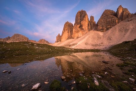 Tre Cime di Lavaredo, Drei Zinnen, reflected in a small lake at sunset, dolomites, Italy