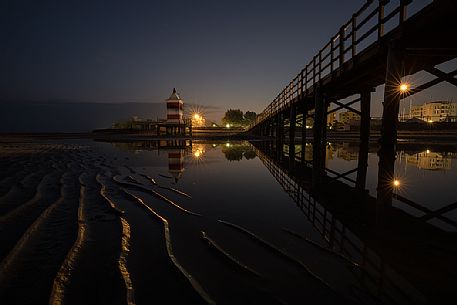 Pier and the old lighthouse by night in Lignano Sabbiadoro, Friuli Venezia Giulia, Italy