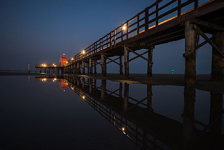 Pier and the old lighthouse by night in Lignano Sabbiadoro, Friuli Venezia Giulia, Italy