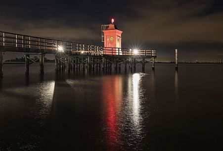 Night view of lighthouse and pier in Punta Faro, Lignano Sabbiadoro, Friuli Venezia Giulia, Italy Night view of lighthouse and pier in Punta Faro, Lignano Sabbiadoro, Friuli Venezia Giulia, Italy