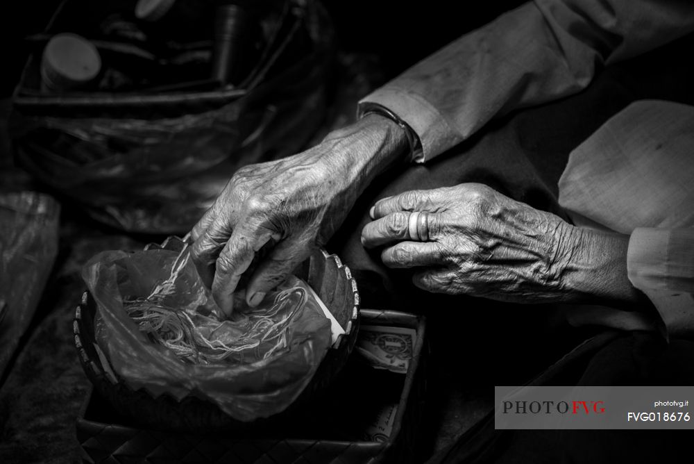 Old woman making bracelets in a Preah Kan temple