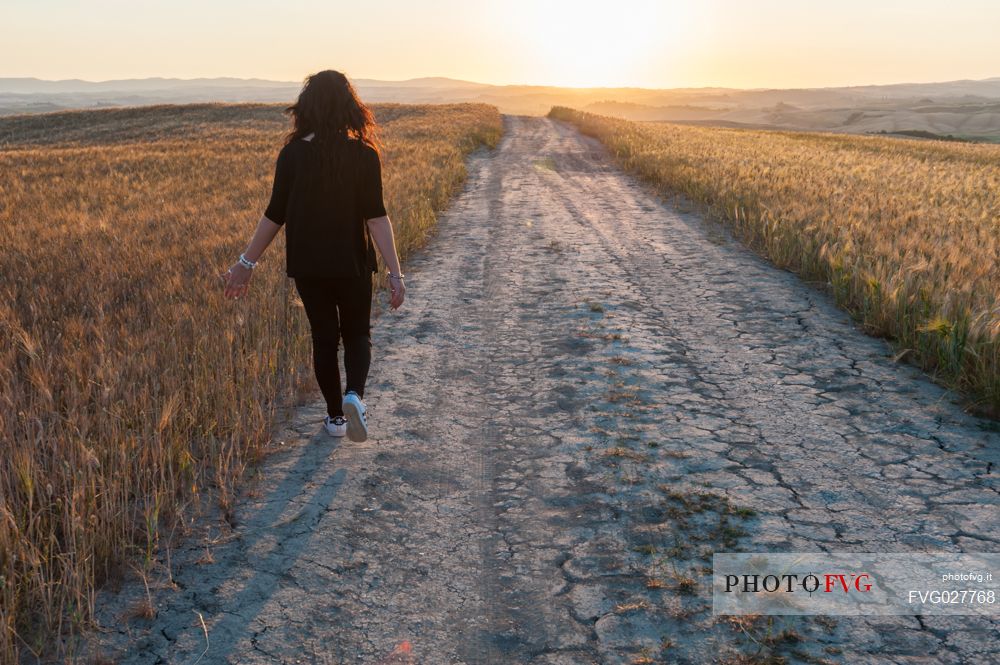 Walking in the Crete Senesi landscape at sunrise, Orcia valley, Tuscany, Italy