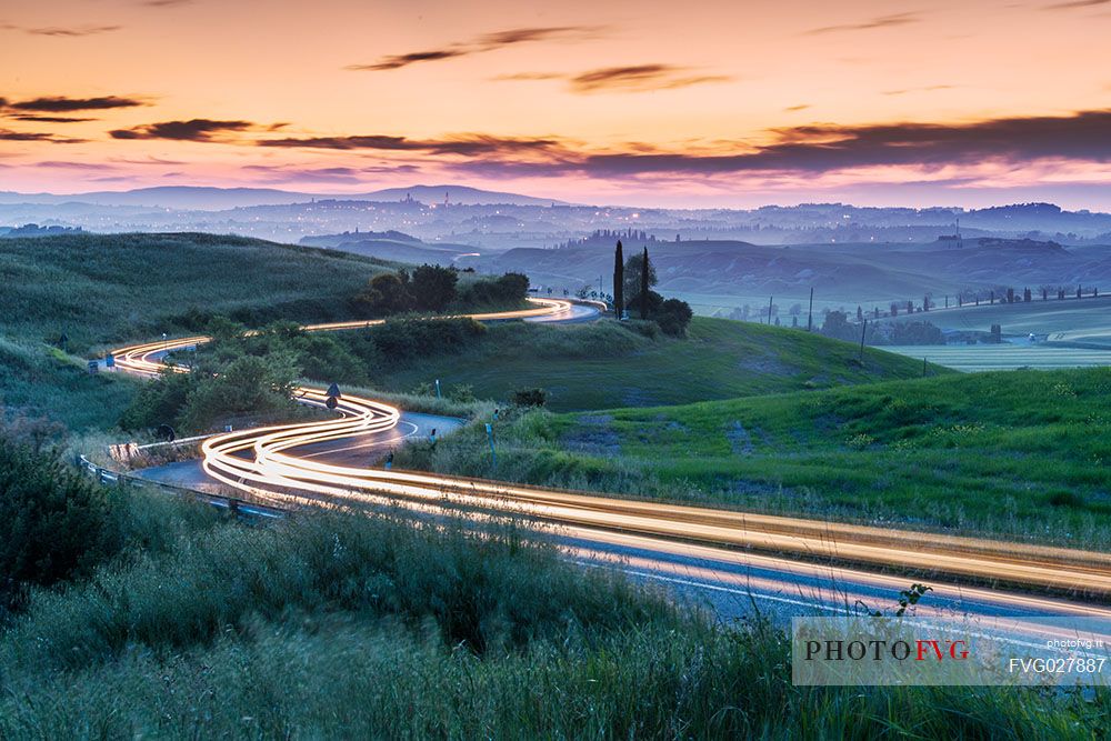 Crete Senesi landscapes, red car light trails on a road, Orcia valley, Tuscany, Italy