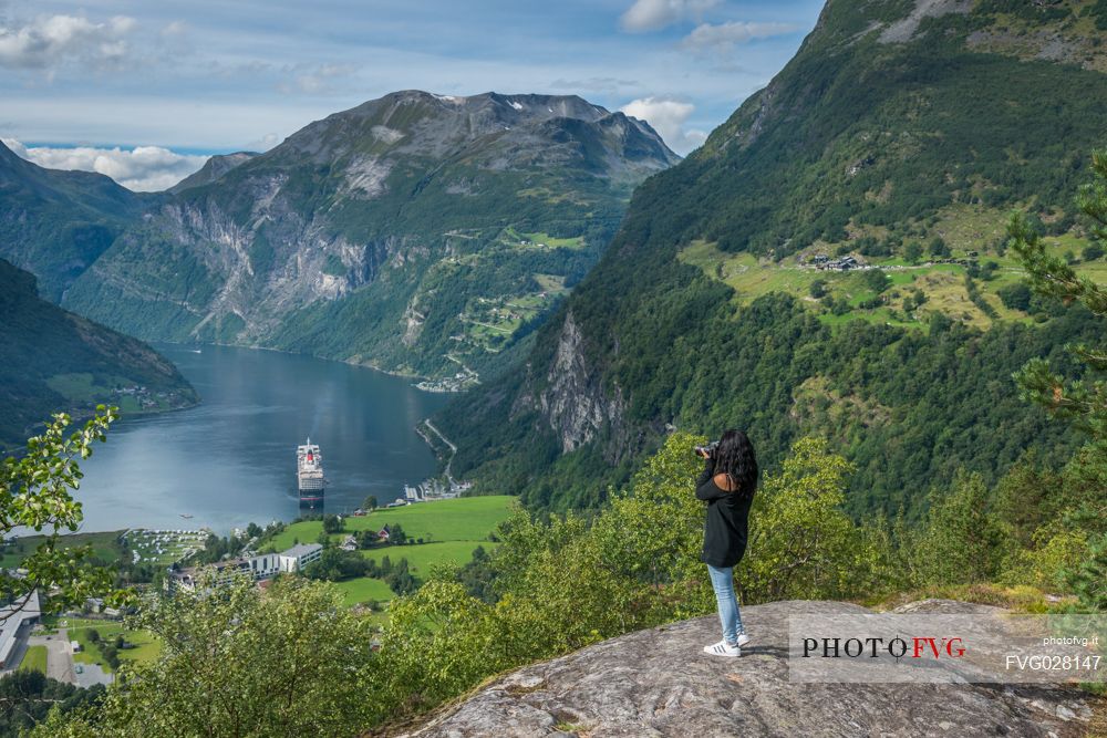 Tourist at the Flydalsjuvet rock looking the Geiranger fjord, Norway