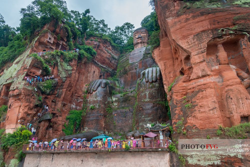 Tourists admiring the Giant Buddha, the largest buddha of the world carved on Emei Shan, sacred mount, Leshan, Sichuan, China