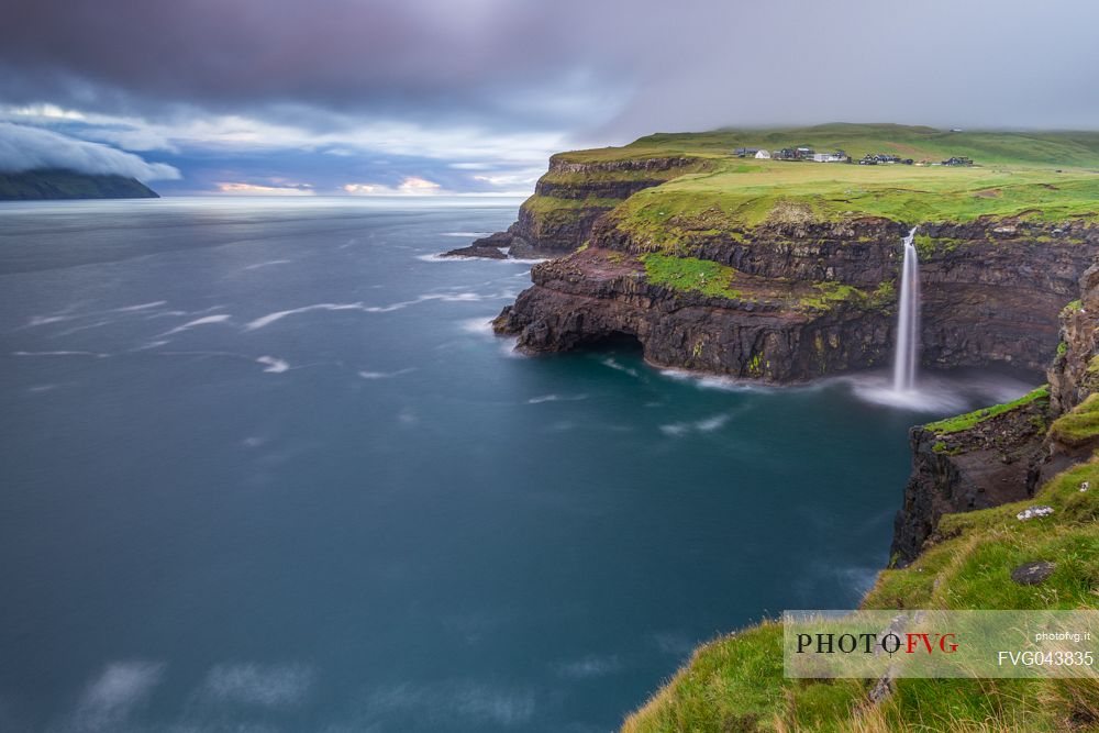 Coast with Mlafossur waterfall and the village of Gsedal or Gsadalur, Vgar Island (Vg), Faeroe Islands, Denmark, Europe