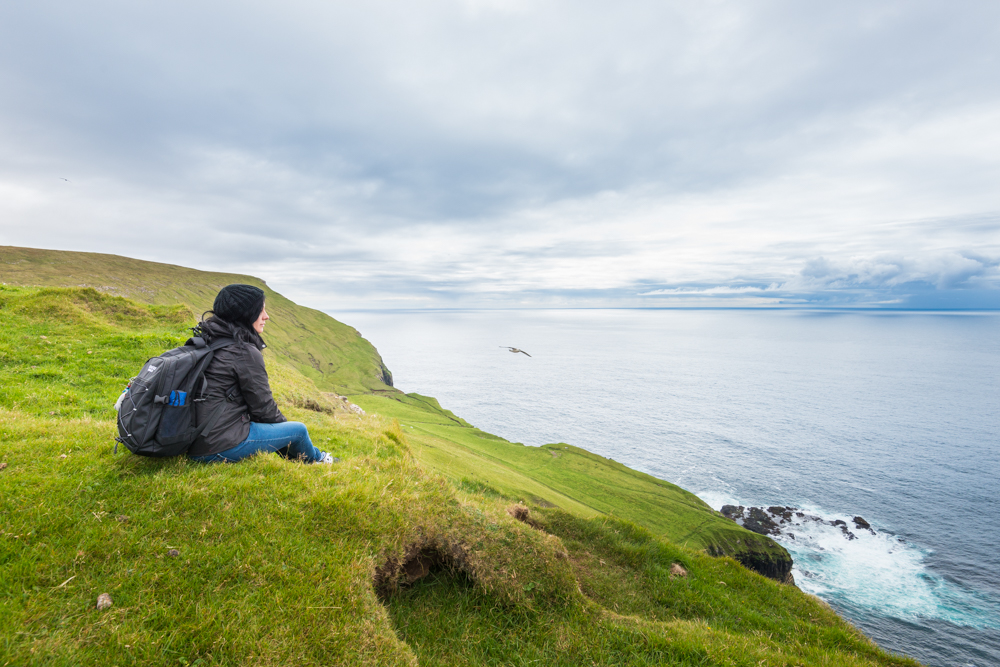 Tourist on the wild coast near Fmjin village, Suouroy island, Faeroe Islands, Denmark, Europe