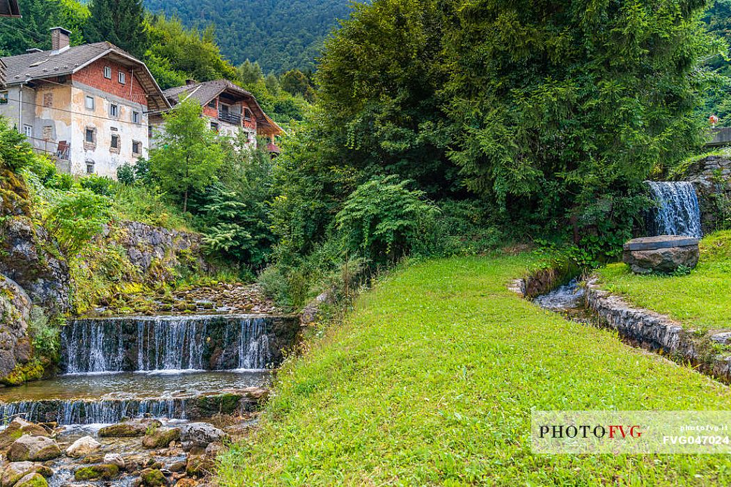 River and traditional houses in the Kropa village, Radovljica, Slovenia, Europe