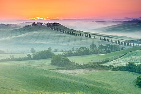 Farm in the Crete Senesi landscape at sunset, Orcia valley, Tuscany, Italy