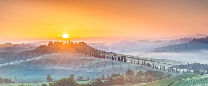 Farm in the Crete Senesi landscape at sunset, Orcia valley, Tuscany, Italy