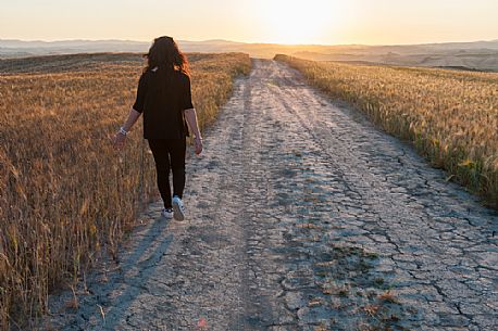 Walking in the Crete Senesi landscape at sunrise, Orcia valley, Tuscany, Italy