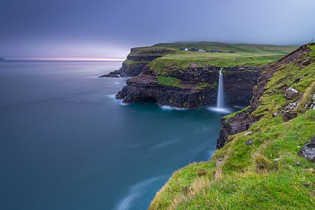 Coast with Múlafossur waterfall and village Gĺsedal or Gásadalur, Vágar Island (Vĺgř), Faeroe Islands, Denmark, Europe Coast with Múlafossur waterfall and village Gĺsedal or Gásadalur, Vágar Island (Vĺgř), Faeroe Islands, Denmark, Europe