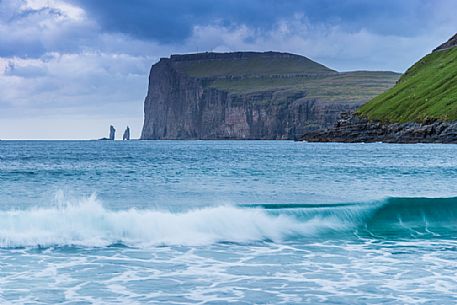 Wild sea and in the background the sea stacks of Risin and Kellingin, just off the northern coast of the island of Eysturoy from Tjornuvik village, Streymoy island, Faeroe islands, Denmark, Europe