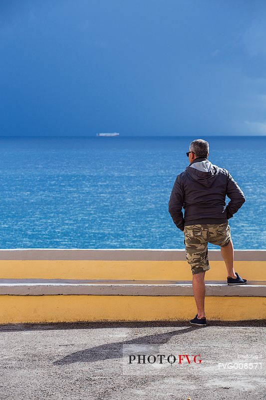man watching a distant ship in Ventotene man watching a distant ship in Ventotene