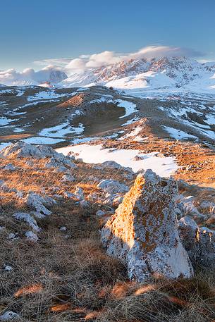 Limestone rocks on the Campo Imperatore plateau. In the background Monte Prena in the sunset light, Gran Sasso national park