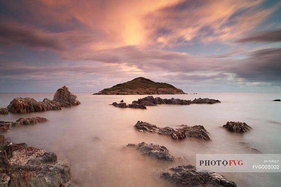 The small island of Campionna located in front of the homonymous beach taken at sunset. This coast is still little known and offers panoramic wild views, Teulada, Sulcis-Iglesiente, Sardinia