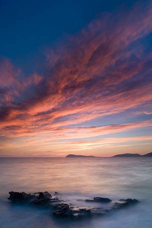 A warm winter sunset along the south west coast of Sardinia. In the background, Capo Teulada