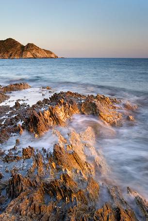 The golden light of sunset lights up the cliffs of Southern Sardinia, Teulada, Sulcis-Iglesiente, Italy