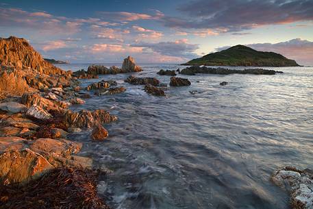 The small island of Campionna taken at sunset and illuminated by a warm golden light, Teulada, Sulcis-Iglesiente, Sardinia, Italy