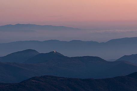 Nighfall from Mount Matajur towards Beata Vergine di Castelmonte sanctuary illuminated, Cividale, Julian Alps, Italy