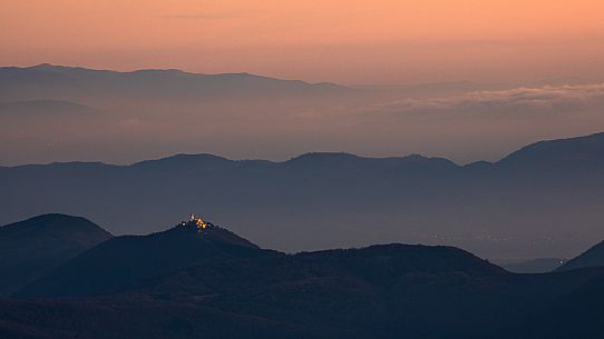 Nighfall from Mount Matajur towards Beata Vergine di Castelmonte sanctuary illuminated, Cividale, Julian Alps, Italy