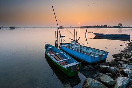 Typical fishing boats in Comacchio lagoon at sunset, Ferrara, Emilia Romagna, Italy