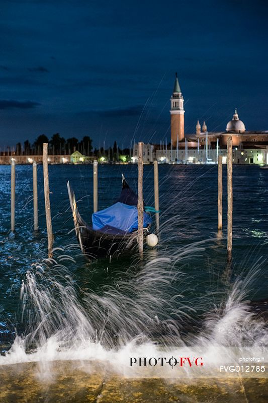 Gondola moored near San Marco's square by night, in the background the San Giorgio Maggiore Basilica, Venice, Veneto, Italy, Europe