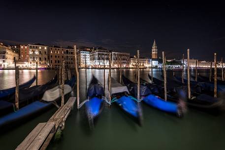 Gondolas moored by night, in the background the Campanile San Marco bell tower and the historical palaces of Venice, Venice, Veneto, Italy, Europe Gondolas moored by night, in the background the Campanile San Marco bell tower and the historical palaces of Venice, Venice, Veneto, Italy, Europe
