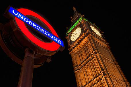 Night view of The Big Ben Tower and underground station sign, London, United Kingdom