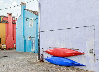 Canoes hanging on the wall of the colorful Burano village, Venice, Italyl, Europe