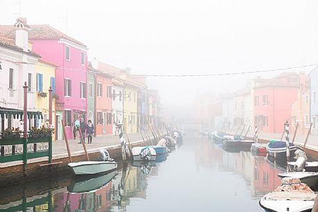 Colorful houses in Burano with canal and moored boats in the fog, Venice, Venetian lagoon, Veneto, Italy, Europe