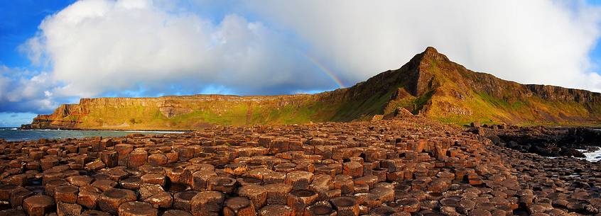 Amazing panoramic view of a rainbow at sunset over the Giant's Causeway, Northern Ireland