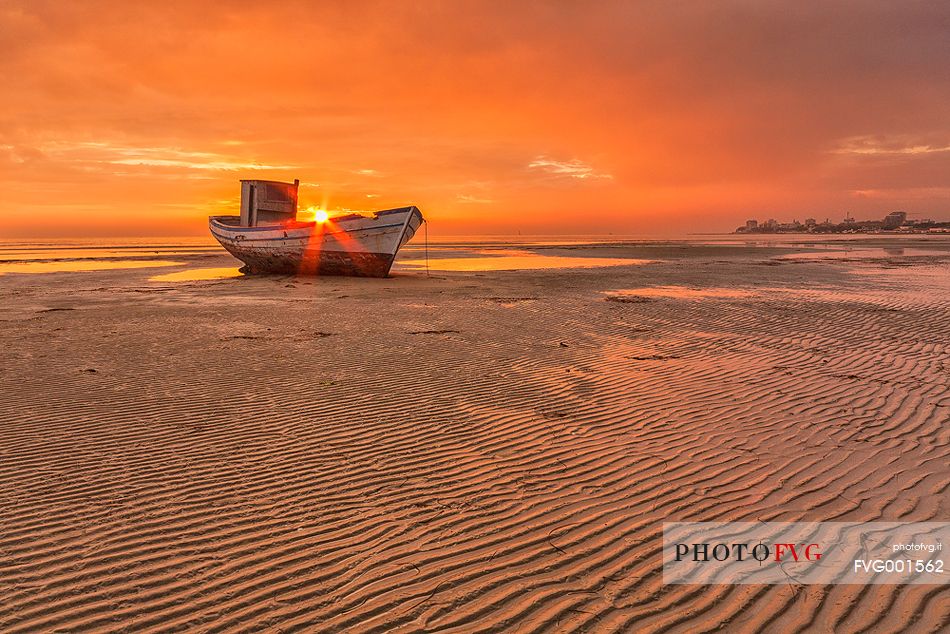 old wreck on sunset in Grado beach