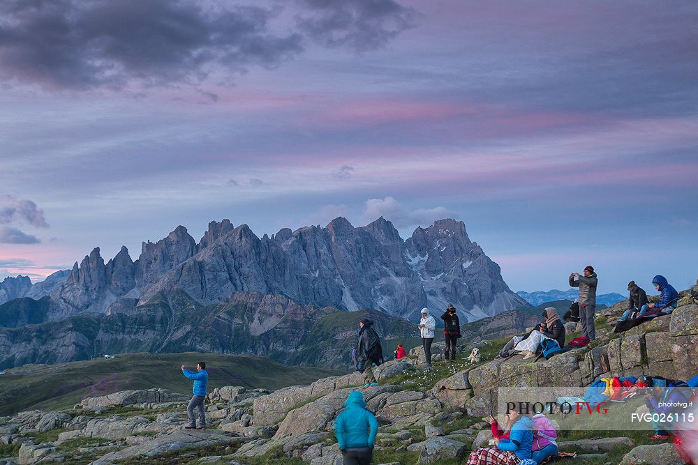 Sounds of the Dolomites, the high altitude music festival in Trentino.  At Sunrise many people listen to a concert on Col Margherita with Pale di San Martino Dolomites in background, dolomites, Italy