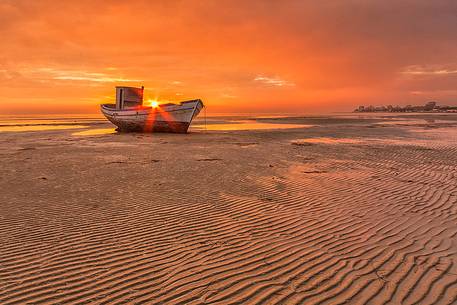 old wreck on sunset in Grado beach