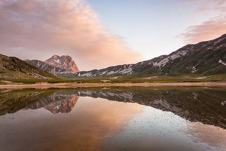 The Corno Grande peak, reflected on the Pietranzoni lake in summer evening
